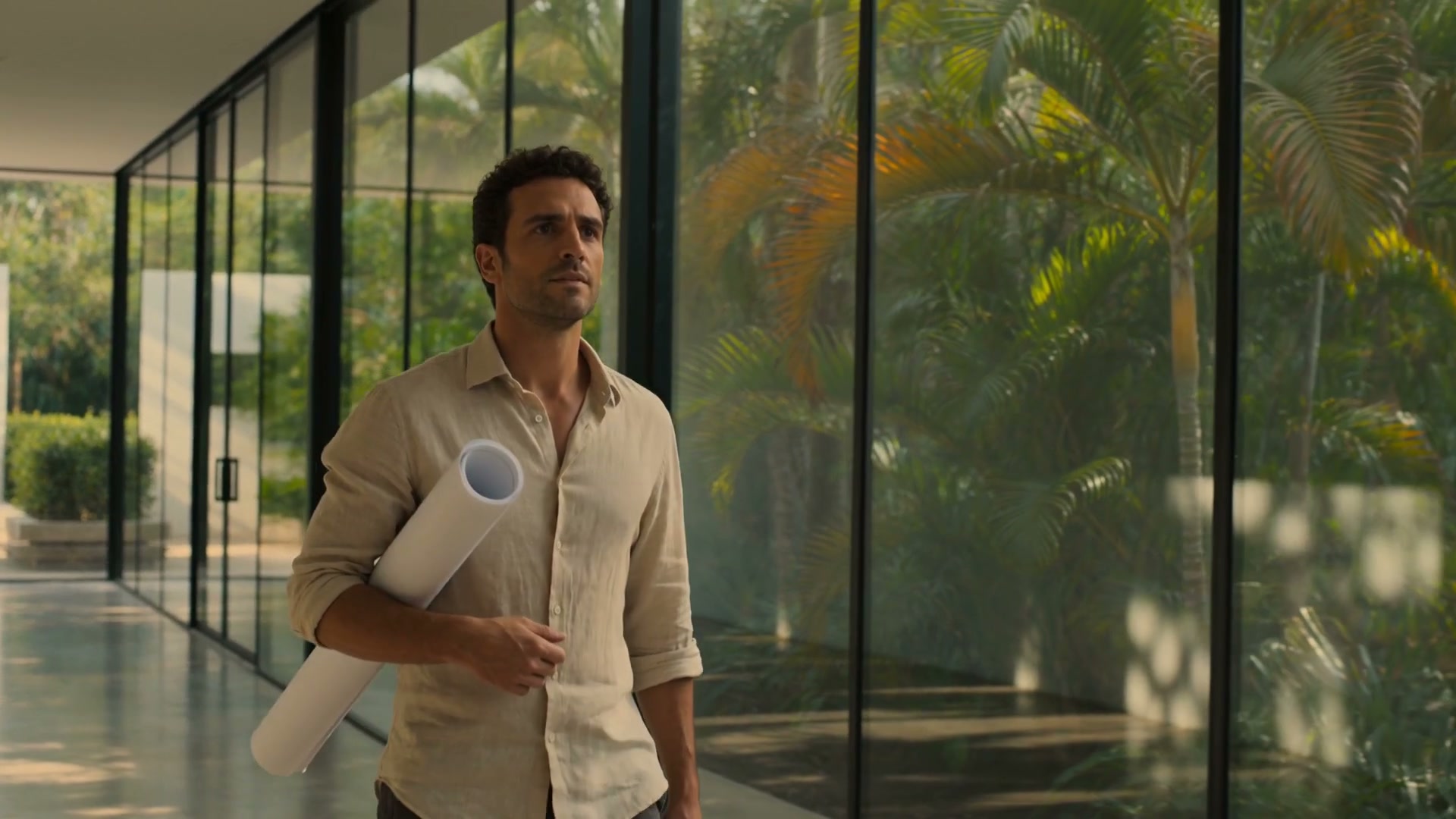 A leader walking through a glass-walled workspace